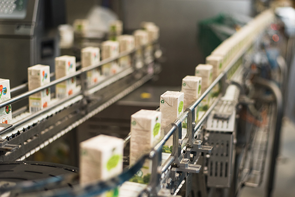 Conveyor at the plant for the production and bottling of juices in cardboard packaging.